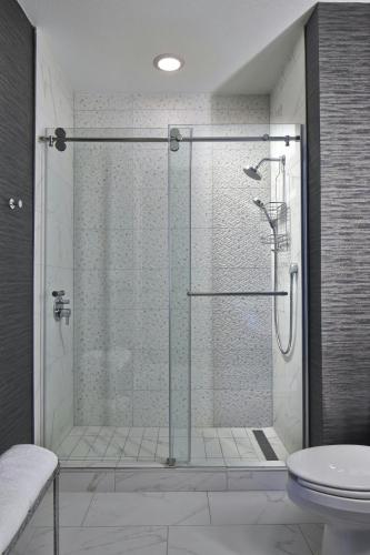 a shower with a glass door in a bathroom at Dallas/Plano Marriott at Legacy Town Center in Plano