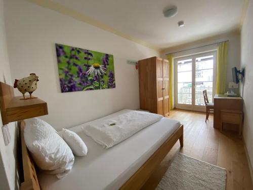 a bedroom with a bed with a flower painting on the wall at Haus Sibylle in Bad Tölz