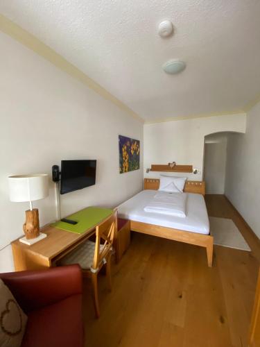 a small room with a bed and a desk at Haus Sibylle in Bad Tölz