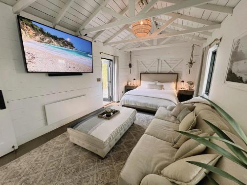 a bedroom with a couch and a tv on the wall at Channel Islands Beach Retreat in Oxnard