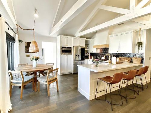 a kitchen with white cabinets and a table and chairs at Channel Islands Beach Retreat in Oxnard