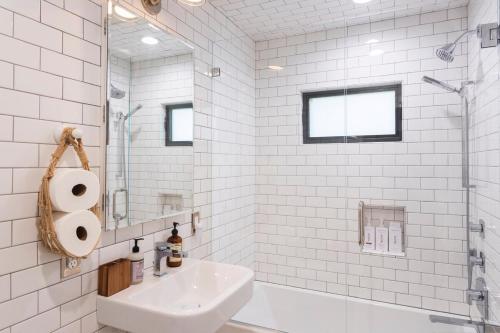 a white bathroom with a sink and a shower at Channel Islands Beach Retreat in Oxnard
