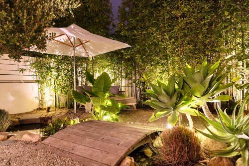 a garden with a wooden bench and an umbrella at Channel Islands Beach Retreat in Oxnard