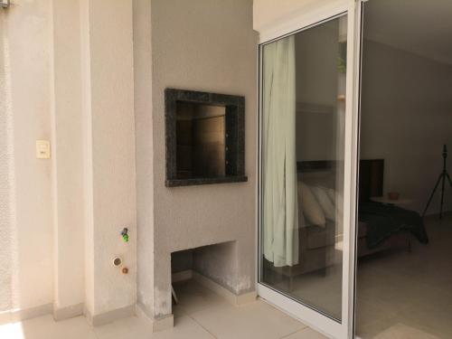 a mirror next to a fireplace in a room at Apartamento com terraço no Rocio Pequeno in São Francisco do Sul