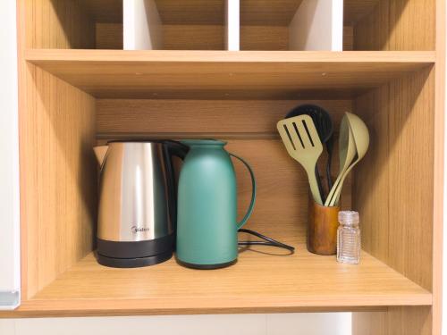 a cupboard with a coffee pot and utensils at Apartamento com terraço no Rocio Pequeno in São Francisco do Sul