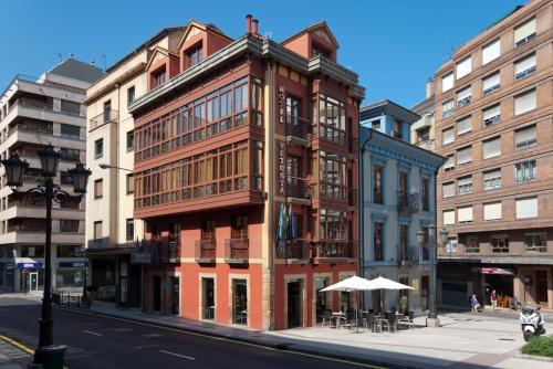 un edificio alto de ladrillo en una calle de la ciudad en Hotel Vetusta en Oviedo