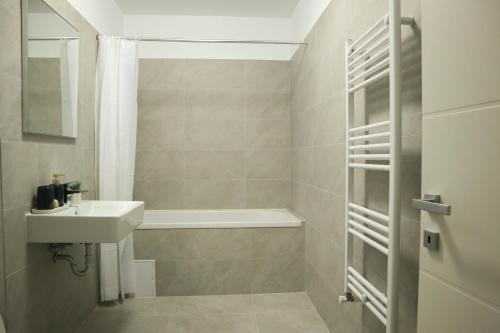 ein Badezimmer mit Waschbecken und Badewanne in der Unterkunft LZR Apartments in Braşov