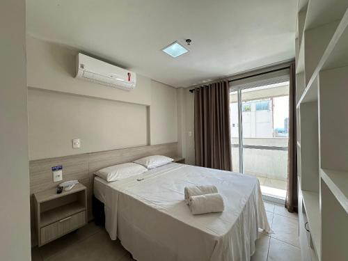 Un dormitorio con una cama blanca con una ventana. en iFlat Brookfield Towers BT2113 Jardim Goiás, en Goiânia