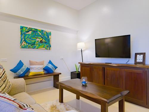 a living room with a couch and a tv at Louis' Apartments in Placencia Village