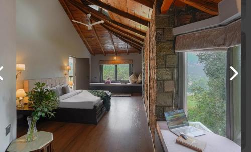 a bedroom with a bed and a desk with a laptop at The Grey House Exotic Luxury-Villa in Bhīm Tāl