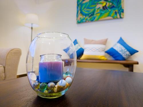 a glass vase with a candle on a table at Louis' Apartments in Placencia Village