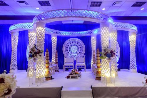 a blue room with a wedding stage with two chairs at Marriott Cincinnati Northeast in Mason