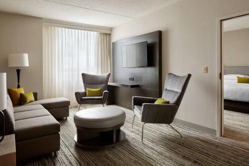 a hotel room with a bed and a living room at Marriott Cincinnati Northeast in Mason