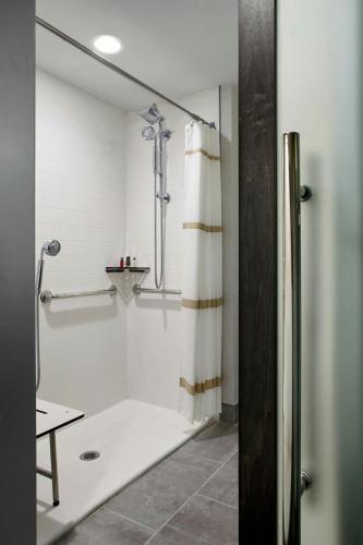a bathroom with a shower with a shower curtain at Marriott Cincinnati Northeast in Mason