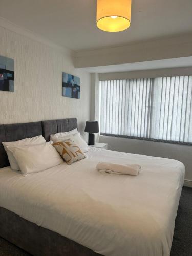 a bedroom with a large bed with white sheets and pillows at Petsol Apartments in Birmingham