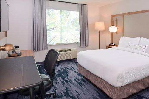 a hotel room with a bed and a desk and a window at Fairfield Inn & Suites by Marriott Pittsburgh New Stanton in New Stanton