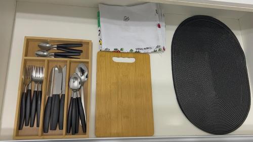a kitchen counter with a cutting board and utensils at Flat aconchegante perto da praia in São Vicente