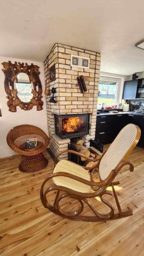 a living room with a chair and a fireplace at Zakątek u Poety Dąbrówka in Jasło