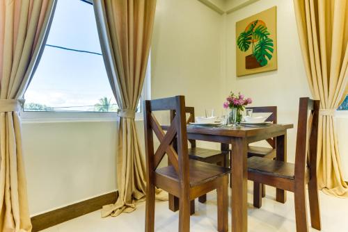 a dining room with a table and chairs and a window at Louis' Apartments in Placencia Village