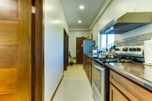 a kitchen with wooden cabinets and a stove top oven at Louis' Apartments in Placencia Village