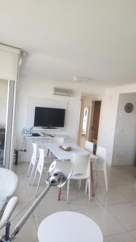 a white dining room with a table and chairs at Gala Vista in Punta del Este
