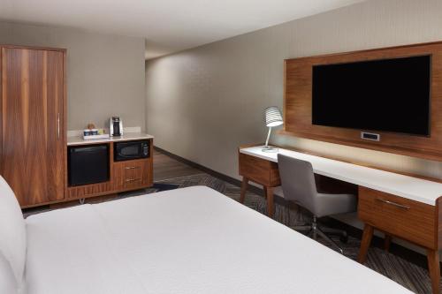 a room with a bed and a desk and a tv at Four Points by Sheraton Vaughan in Vaughan