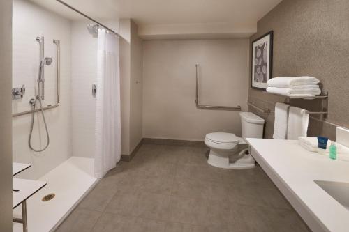 a bathroom with a toilet and a shower and a sink at Four Points by Sheraton Vaughan in Vaughan