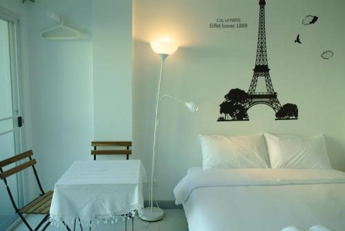 1 dormitorio con 1 cama con la torre Eiffel en la pared en V Suvarnabhumi วี สุวรรณภูมิ, en Bang Phli