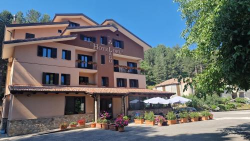 a hotel building with flowers in front of it at Hotel del Lago Ampollino in Torre Caprara