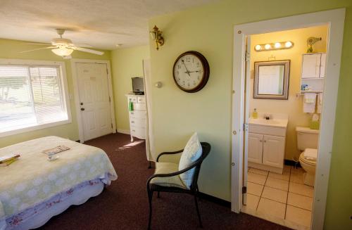 a bedroom with a bed and a clock on the wall at Savannah House Wine Country Inn & Cottages in Himrod