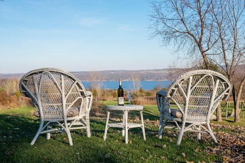 two wicker chairs and a table with a bottle of wine at Savannah House Wine Country Inn & Cottages in Himrod
