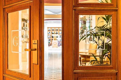 a wooden door with a potted plant in a room at Hotel Grande Bretagne, a Luxury Collection Hotel, Athens in Athens
