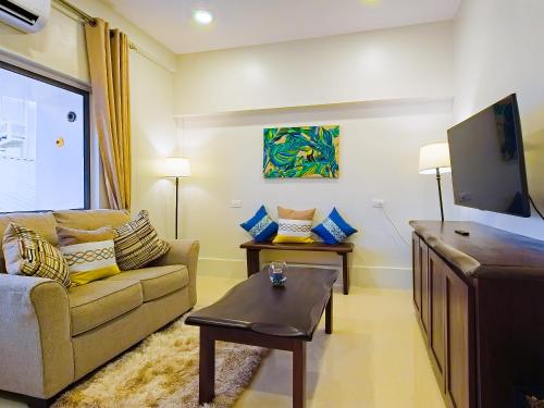 a living room with a couch and a flat screen tv at Louis' Apartments in Placencia Village