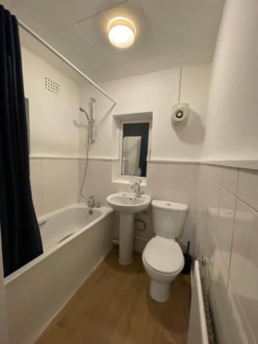 a white bathroom with a toilet and a sink at Sidcup Stay in Sidcup