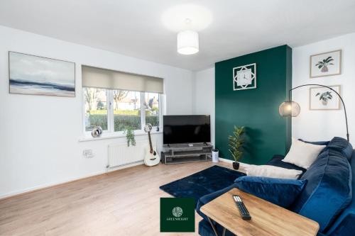 a living room with a blue couch and a tv at 3 Bed House with King Size bed near Uni and QMC in Nottingham