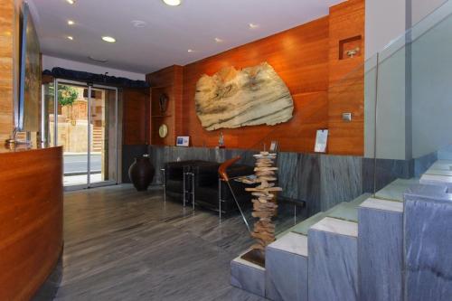 a living room with a lobby with a rock on the wall at Hotel Vetusta in Oviedo