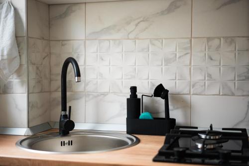 a kitchen counter with a sink and a stove at Szilárd Apartment in Miercurea-Ciuc