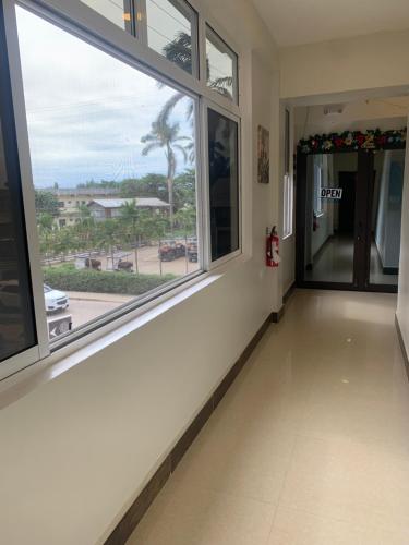 a hallway with two windows and a view of a street at Louis' Apartments in Placencia Village
