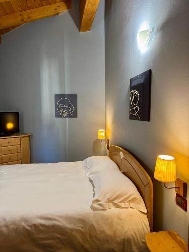 a bedroom with a bed and a tv on the wall at Marangon Apartments in Sùtrio