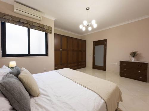 a large bedroom with a white bed and a window at Jacuzzi Terrace Getaway with Valletta Views in Sliema