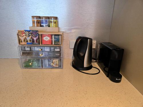 a computer monitor sitting on a floor next to a book shelf at Cairns Reefside Retreats in Cairns