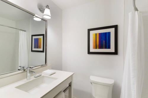 a bathroom with a sink and a toilet and a mirror at Four Points by Sheraton Surrey in Surrey