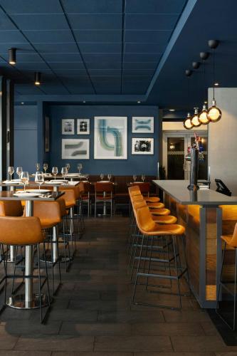 a restaurant with tables and chairs and a bar at Four Points by Sheraton Surrey in Surrey