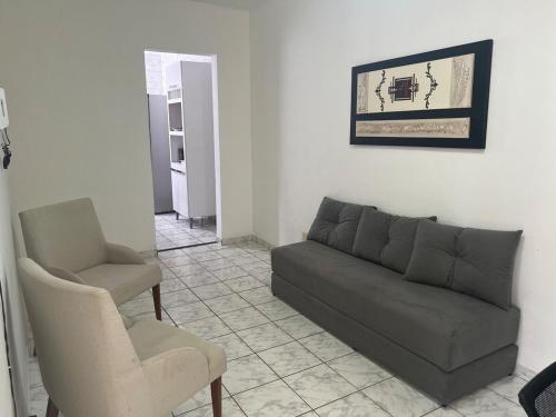 a living room with a couch and a chair at Cantinho aos pés do Ibituruna in Governador Valadares