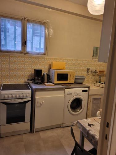une cuisine avec un micro-ondes et un lave-linge dans l'établissement 2 pieces pour 4 personnes proche tram, à Nice