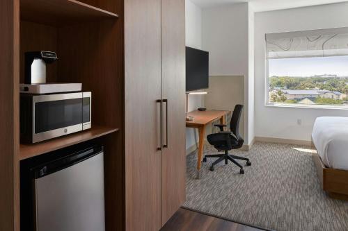 a hotel room with a bed and a desk with a tv at Element by Westin Orlando International Drive in Orlando