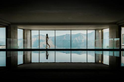 a woman walking in a building with a pool of water at JW Marriott Mussoorie Walnut Grove Resort & Spa in Mussoorie