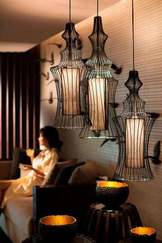 a woman sitting on a couch in a room with lights at JW Marriott Mussoorie Walnut Grove Resort & Spa in Mussoorie