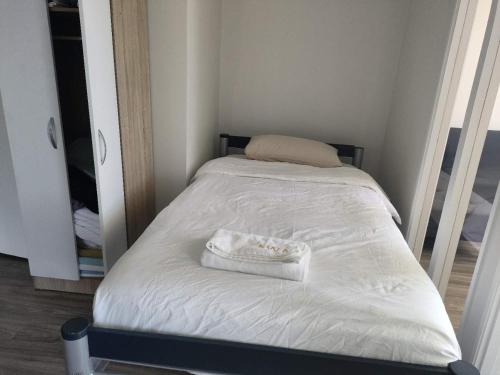 a small bed with a white towel on it at 9 Beds including 3 Double Beds, 4 Single Beds, 2 Sofa Bed, Suite 1, 37 Totara Avenue, New Lynn in Auckland