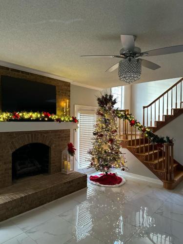 a christmas tree in a living room with a fireplace at Whisper Chateau Weddings Reunions Groups 75 Plus in Greensboro